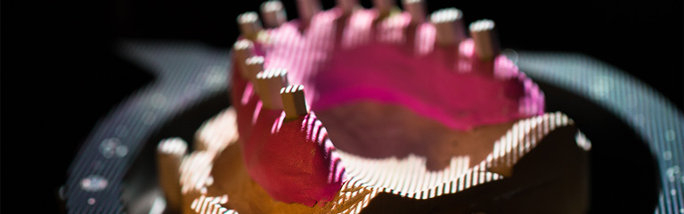 Photograph of a digital dental scanner scanning a mouth mold.